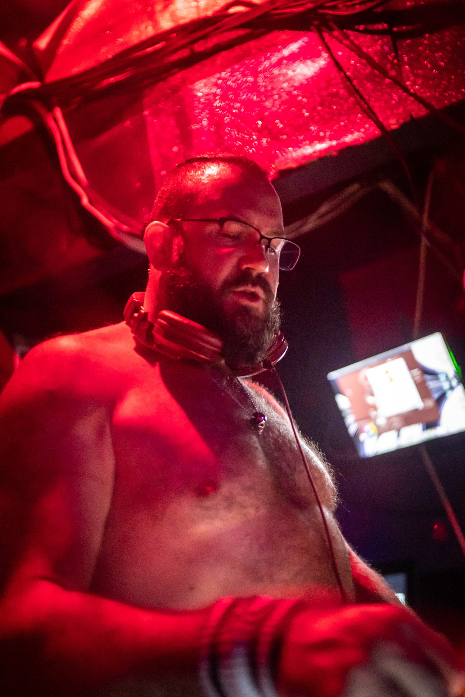 A performer mid-set under red light, by Felix Xie